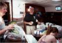 Gitte, Ben, and Kathy stow the food while Emilie keeps inventory.